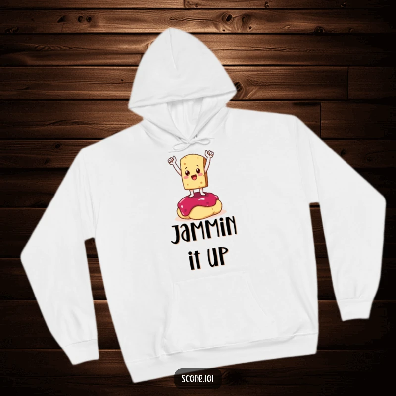 Funny Hoodie: A scone character strikes a triumphant pose on a dollop of jam, symbolizing victory and coziness.