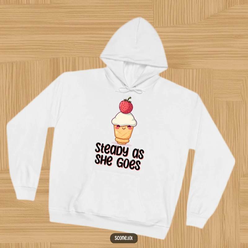 Funny scone hoodie featuring a smiling scone precariously balancing a wobbly berry on its head, offering warmth and humor as a funny gift.